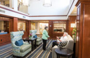 Friendly neighbors conversing in retirement community lobby