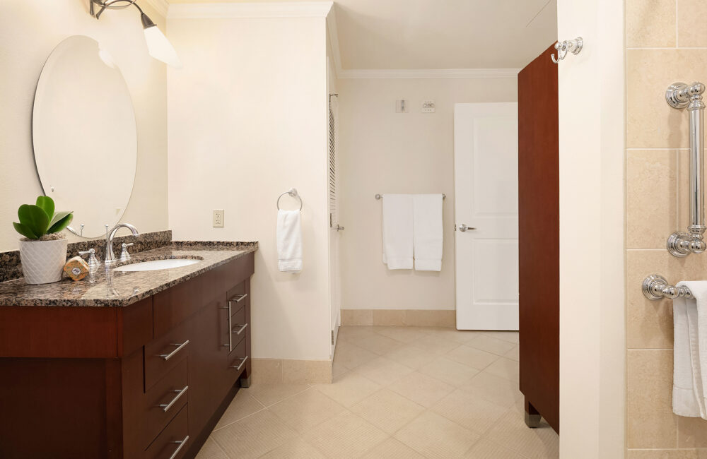 A spacious bathroom with large mirror and accessibility features at Aljoya Mercer Island retirement community in Mercer Island.