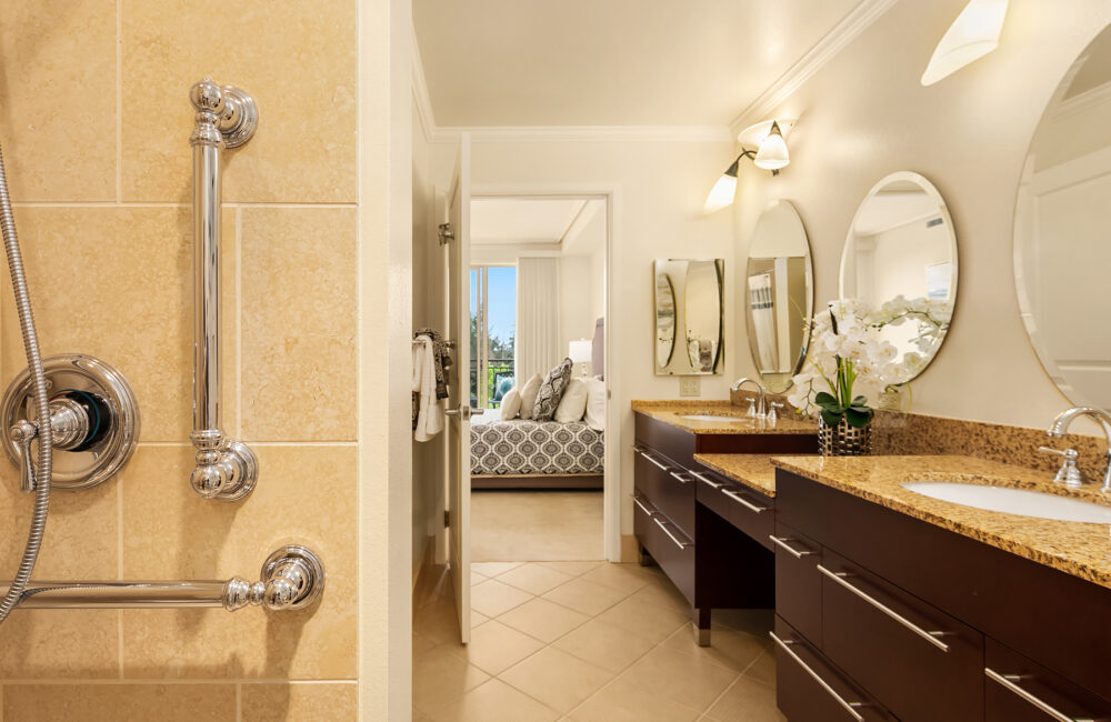 A spacious bathroom with double sinks and accessible grab bars at Aljoya Mercer Island retirement community in Mercer Island.