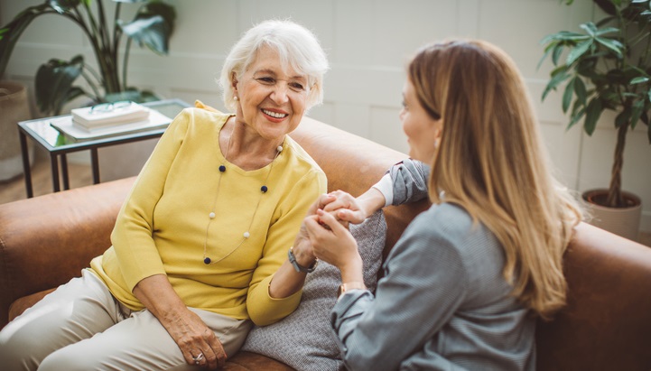 Mother and daughter sitting together on a sofa talking