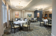 Elegant resident dining room with warm colors and bright lighting.