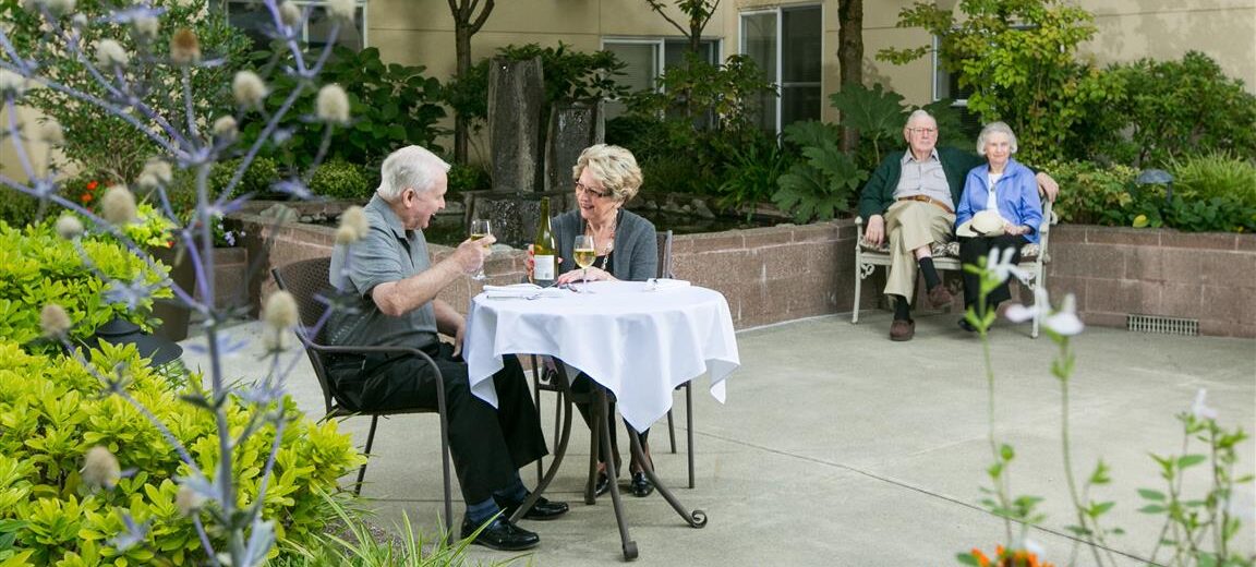 Older couples dining in the garden courtyard on a summer day