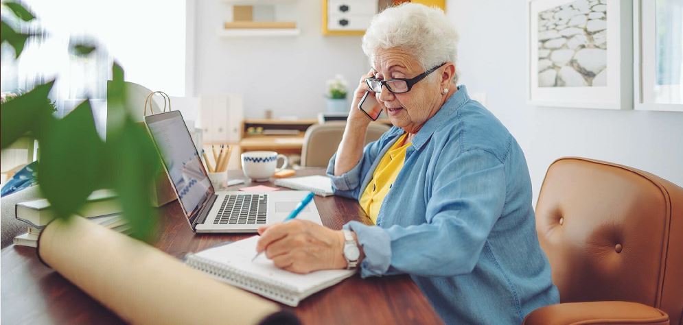 Woman on the phone taking notes to avoid scams