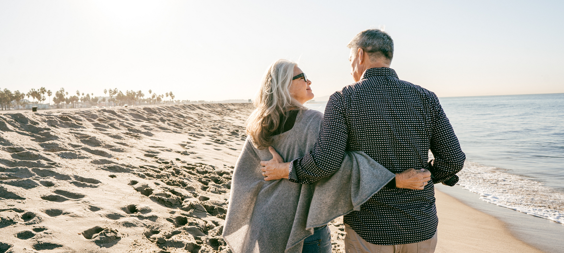 Middle aged couple walking along a beach