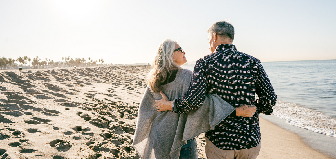 Middle aged couple walking along a beach