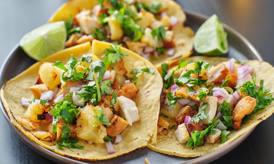 A close up of 3 mahi-mahi street tacos with pinapple salsa