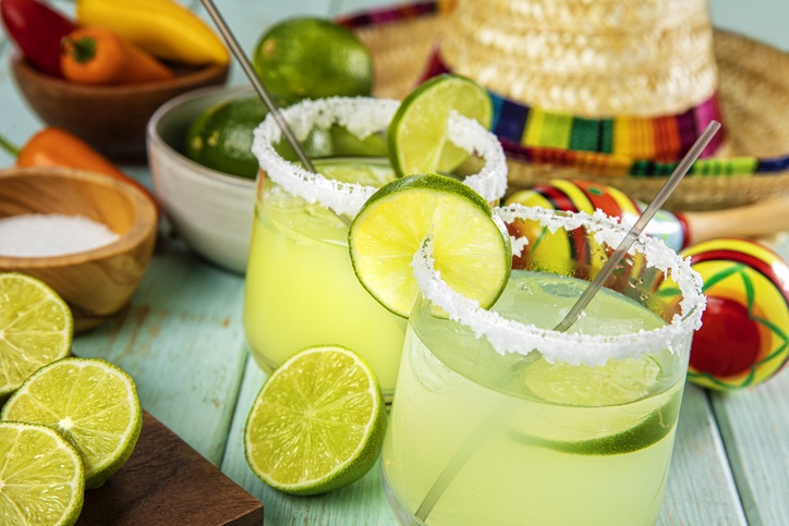 Margaritas with salt & limes with a festive bckground.