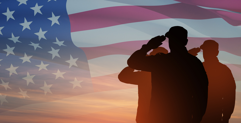 Sillouette of 3 veterans saluting the American Flag
